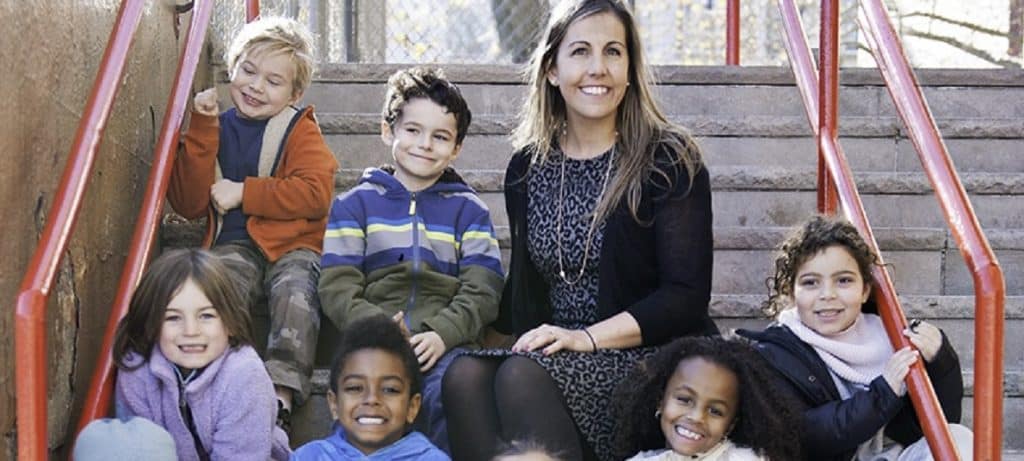 Principal Dello Stritto sitting on steps with students